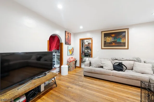a bedroom with a bed a large window and a chandelier