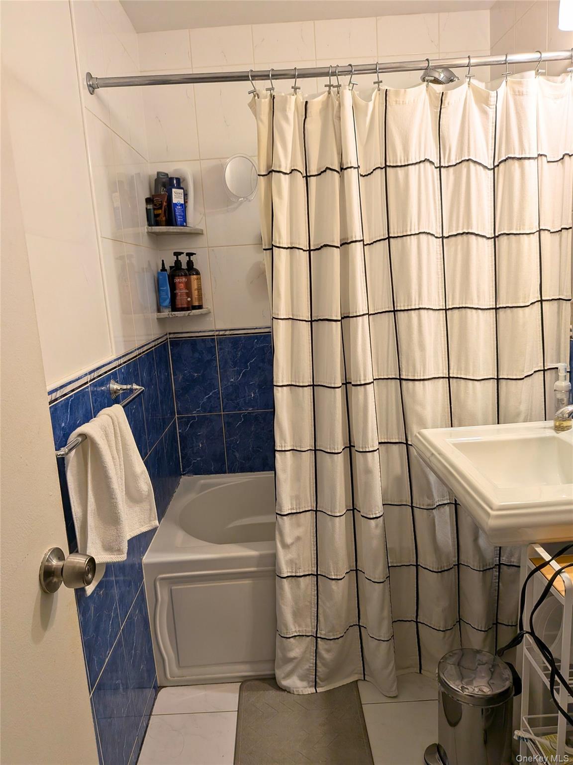 75-24 Bell Boulevard, Unit LD Queens, NY 11364 - Photo 10 of 19 a bathroom with a sink and a shower curtain