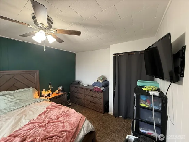 a bedroom with a bed and a flat tv screen on the dresser