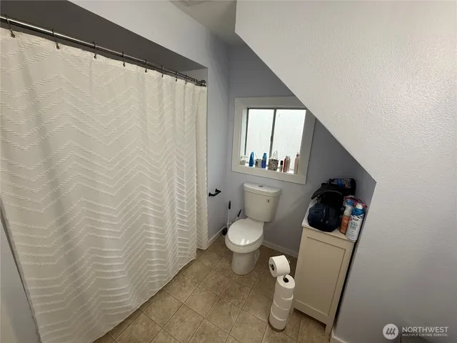 a bathroom with a toilet and a shower curtain