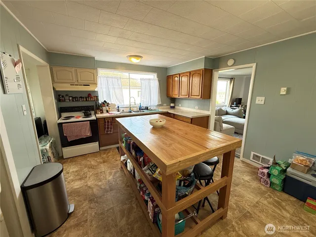 a kitchen with a stove a refrigerator and a sink