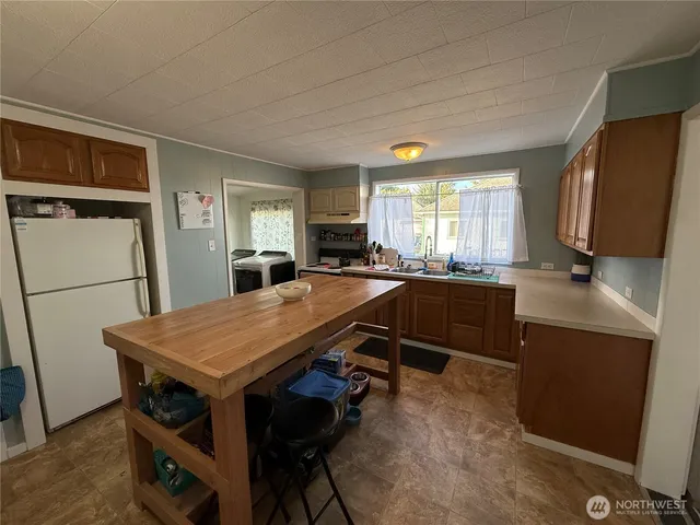 a kitchen with a table chairs refrigerator and microwave