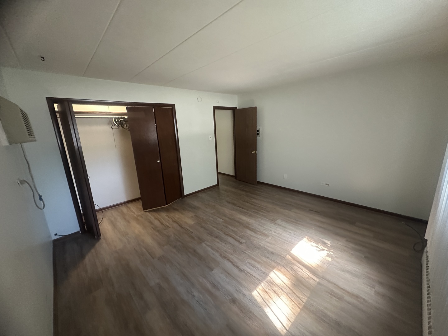 18550 Torrence Avenue, Unit 4 Lansing, IL 60438 - Photo 6 of 14 an empty room with wooden floor and windows