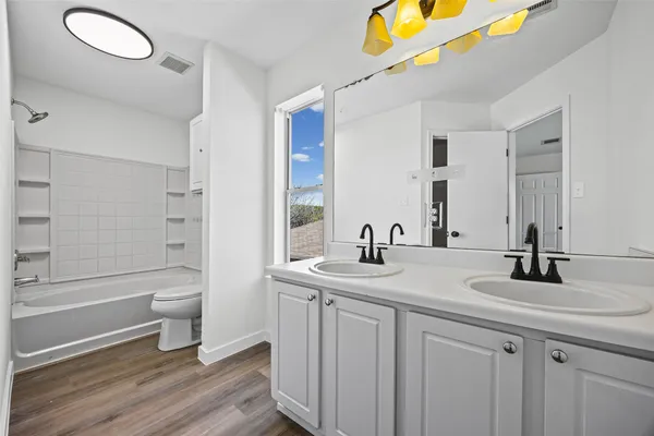 a bathroom with a granite countertop sink a toilet and a large mirror