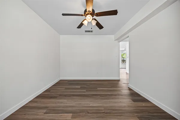 a view of room with hardwood floor and ceiling fan