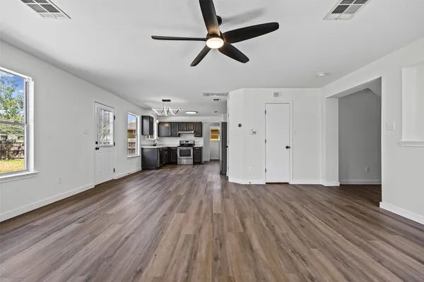 a view of empty room with wooden floor and window
