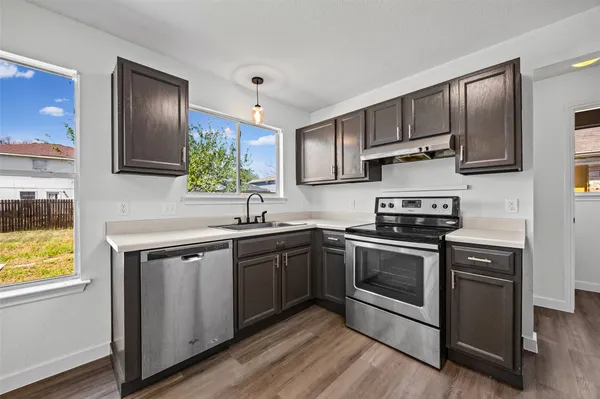 a kitchen with stainless steel appliances granite countertop a stove a sink and a microwave