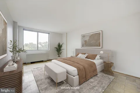 a bedroom with a bed wooden floor and window