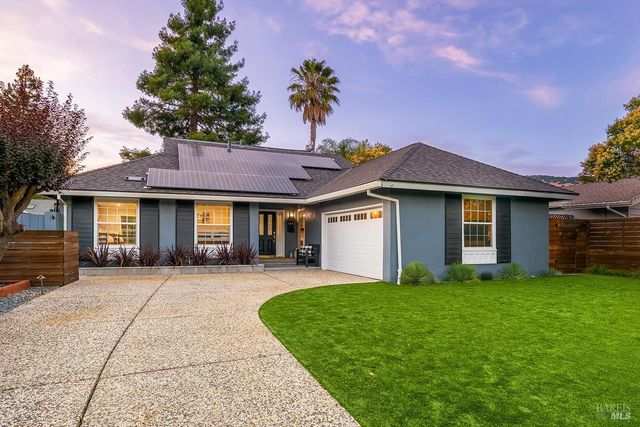 a front view of a house with a yard and trees