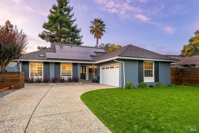 a front view of a house with a yard and trees