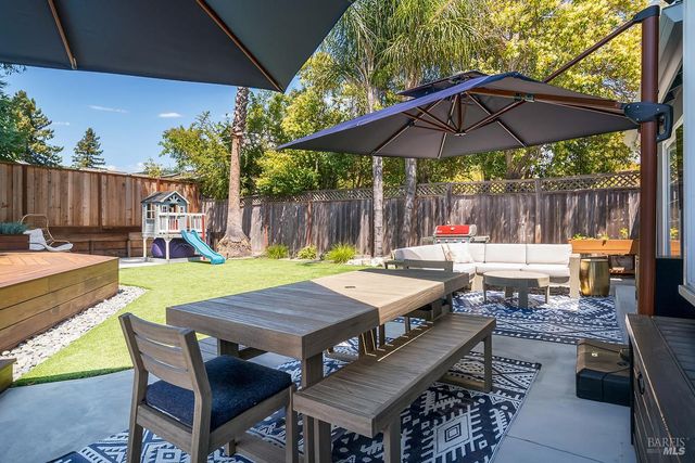 a patio with a table and chairs under an umbrella