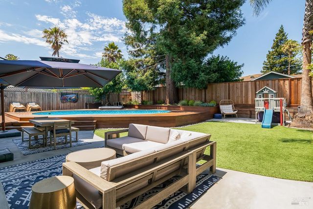 an outdoor sitting area with furniture and umbrella