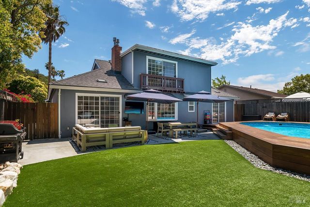 a front view of a house with swimming pool having outdoor seating