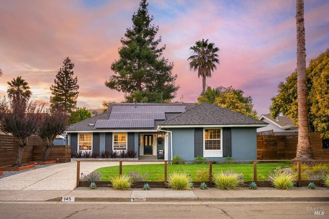 a front view of a house with a garden and plants