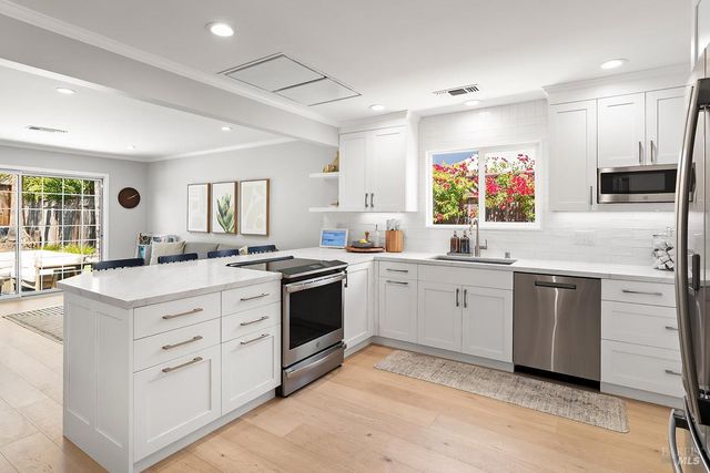 a kitchen with white cabinets and stainless steel appliances