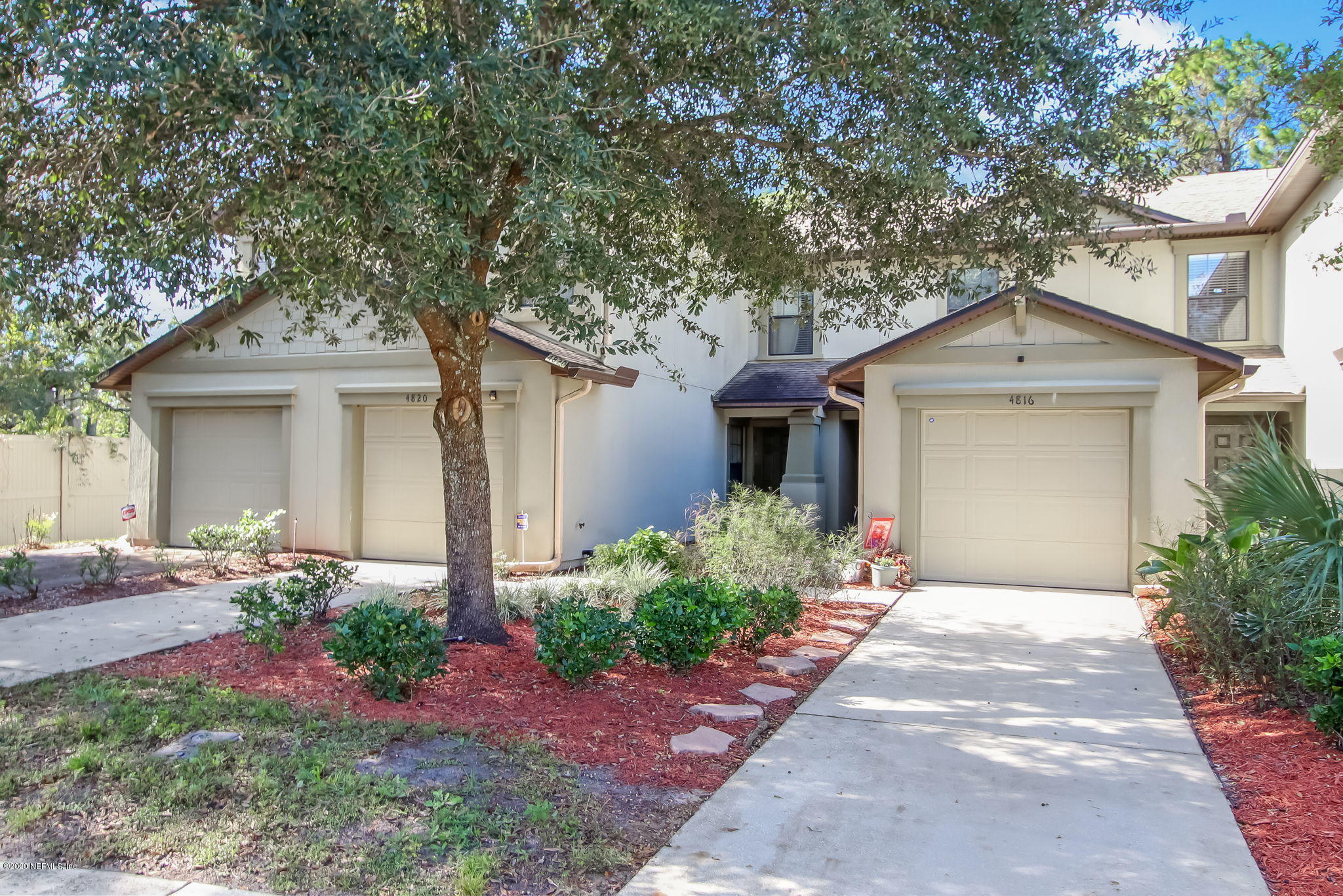 a front view of a house with a garden and plants