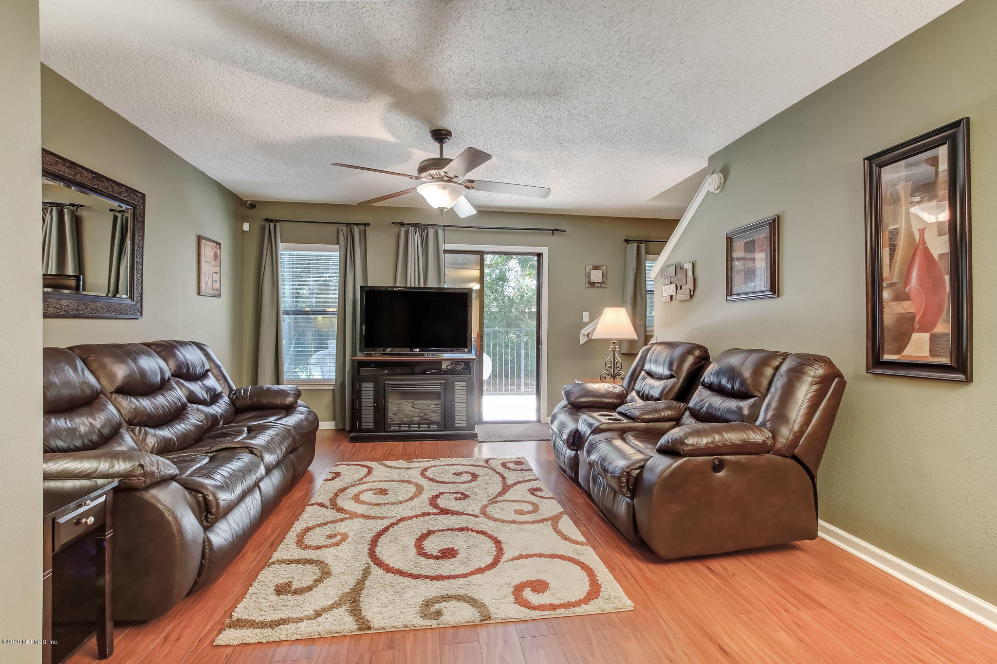 4816 Playschool Drive Jacksonville, FL 32210 - Photo 6 of 49 a living room with furniture a flat screen tv and a chandelier