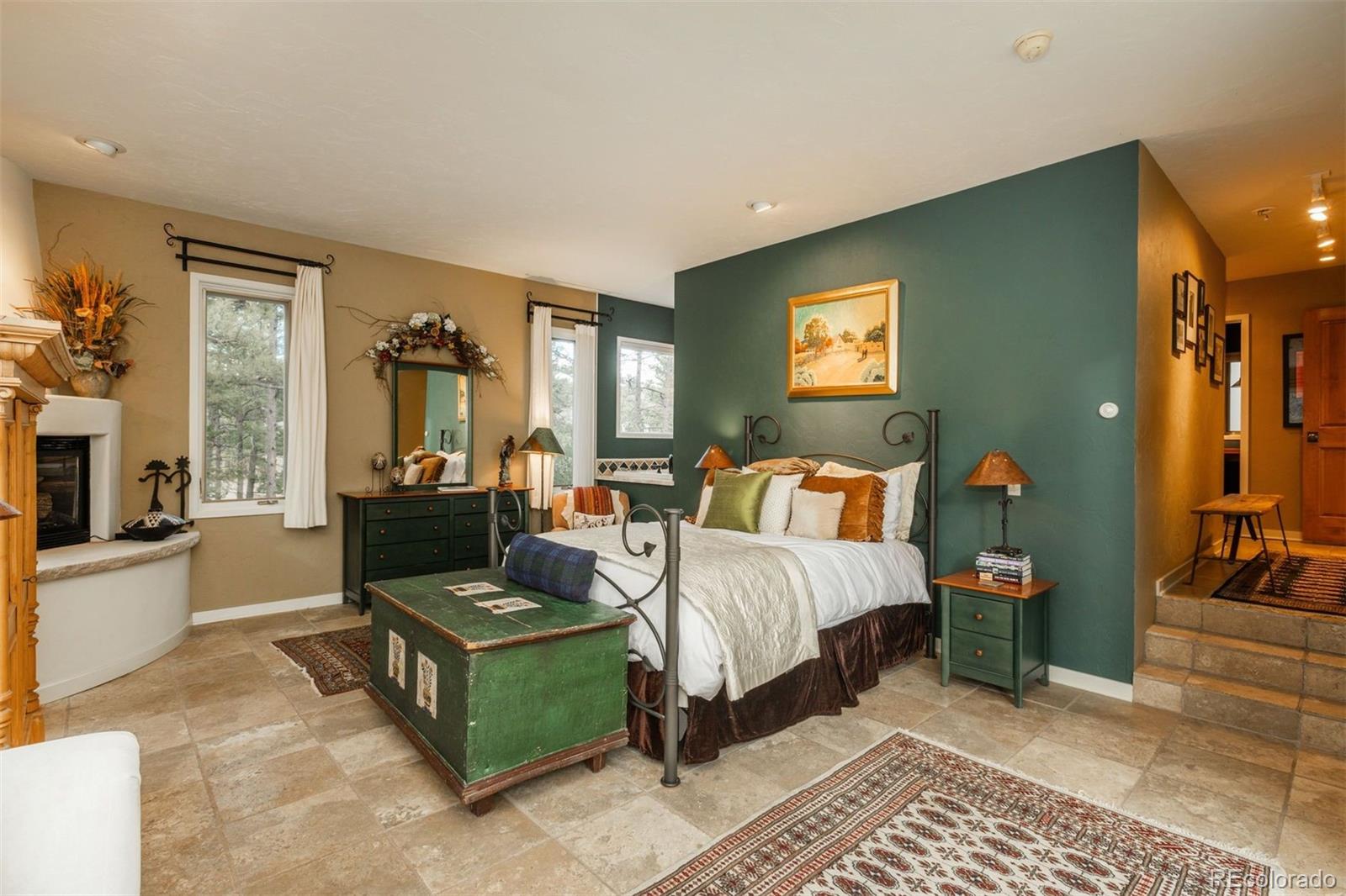 1551 Genesee Ridge Road Golden, CO 80401 - Photo 15 of 50 a spacious bedroom with a bed a couch and dresser