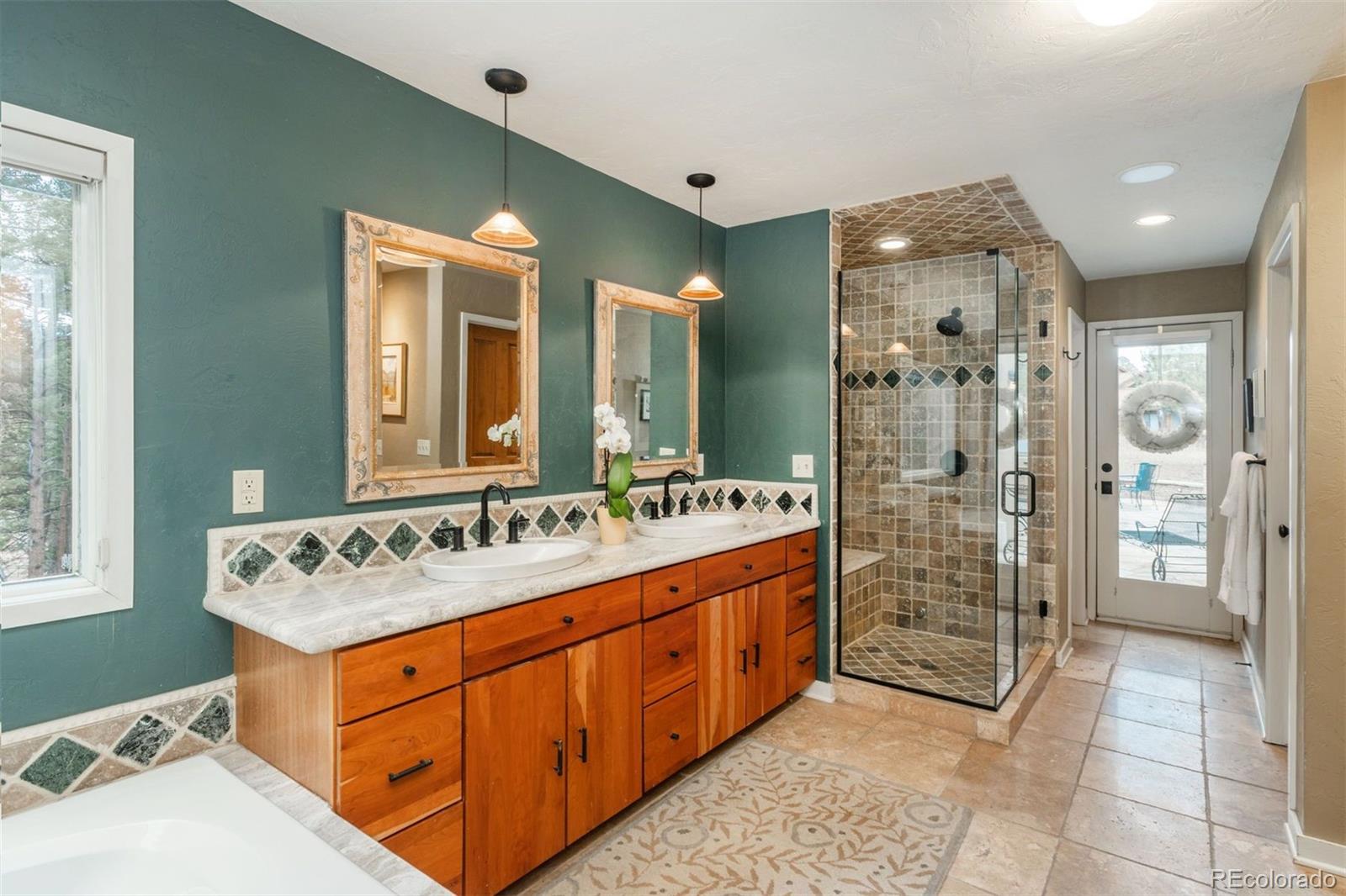 1551 Genesee Ridge Road Golden, CO 80401 - Photo 19 of 50 a bathroom with a sink mirror and shower