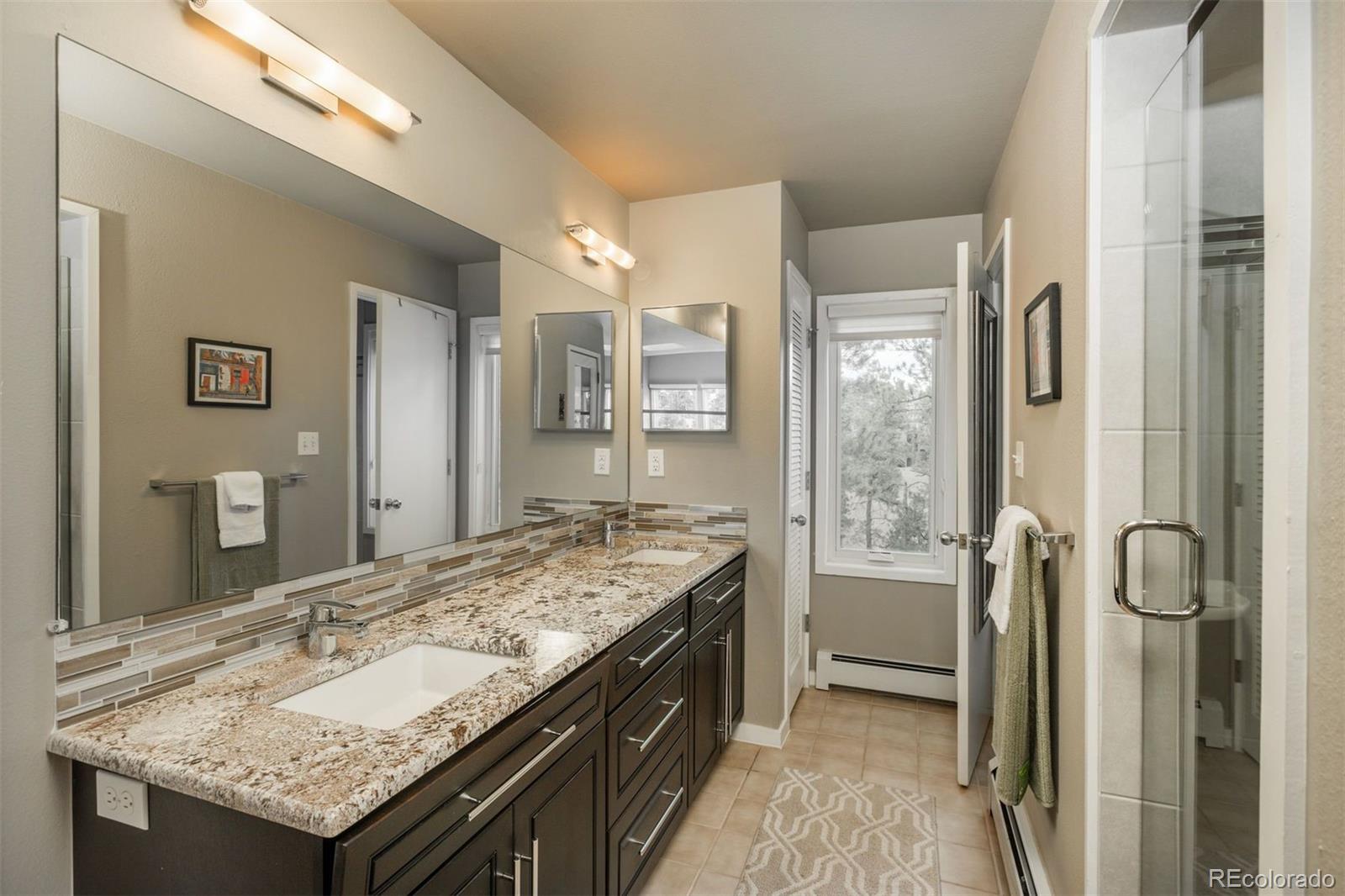 1551 Genesee Ridge Road Golden, CO 80401 - Photo 31 of 50 a bathroom with a granite countertop sink and a mirror
