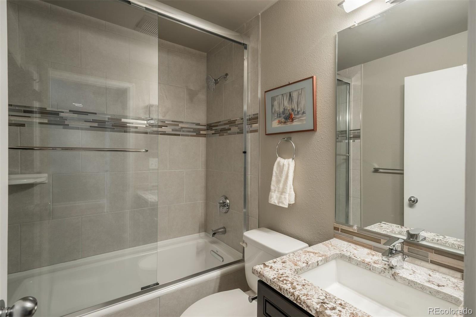 1551 Genesee Ridge Road Golden, CO 80401 - Photo 35 of 50 a bathroom with a granite countertop sink mirror toilet and bathtub