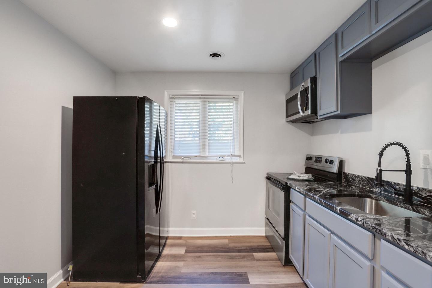 5504 Keppler Road Temple Hills, MD 20748 - Photo 12 of 19 a kitchen with stainless steel appliances granite countertop a refrigerator and a sink