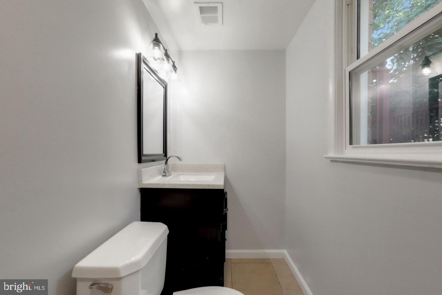 5504 Keppler Road Temple Hills, MD 20748 - Photo 14 of 19 a bathroom with a sink a toilet a mirror and vanity