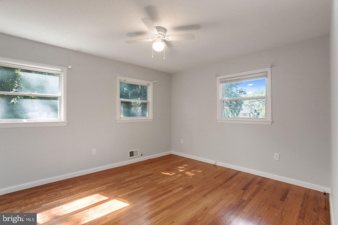 5504 Keppler Road Temple Hills, MD 20748 - Photo 6 of 19 a view of empty room with wooden floor and fan