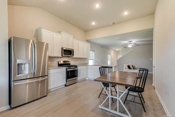 a kitchen with kitchen island a refrigerator and a stove top oven