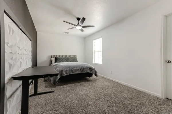 a bedroom with a bed window and a wall painting