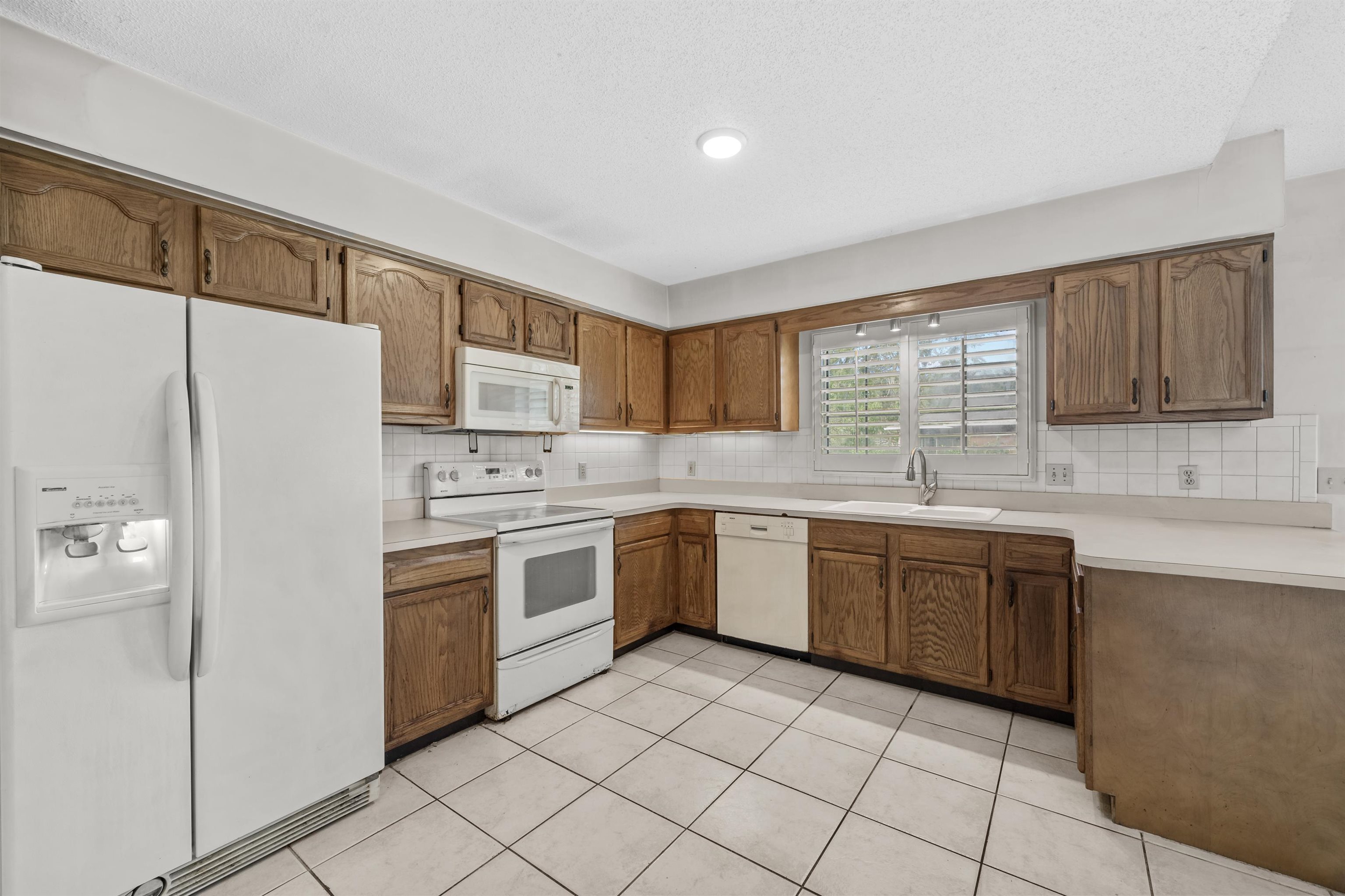 240 Watson Road St. Augustine, FL 32086 - Photo 15 of 43 a kitchen with a sink window and refrigerator