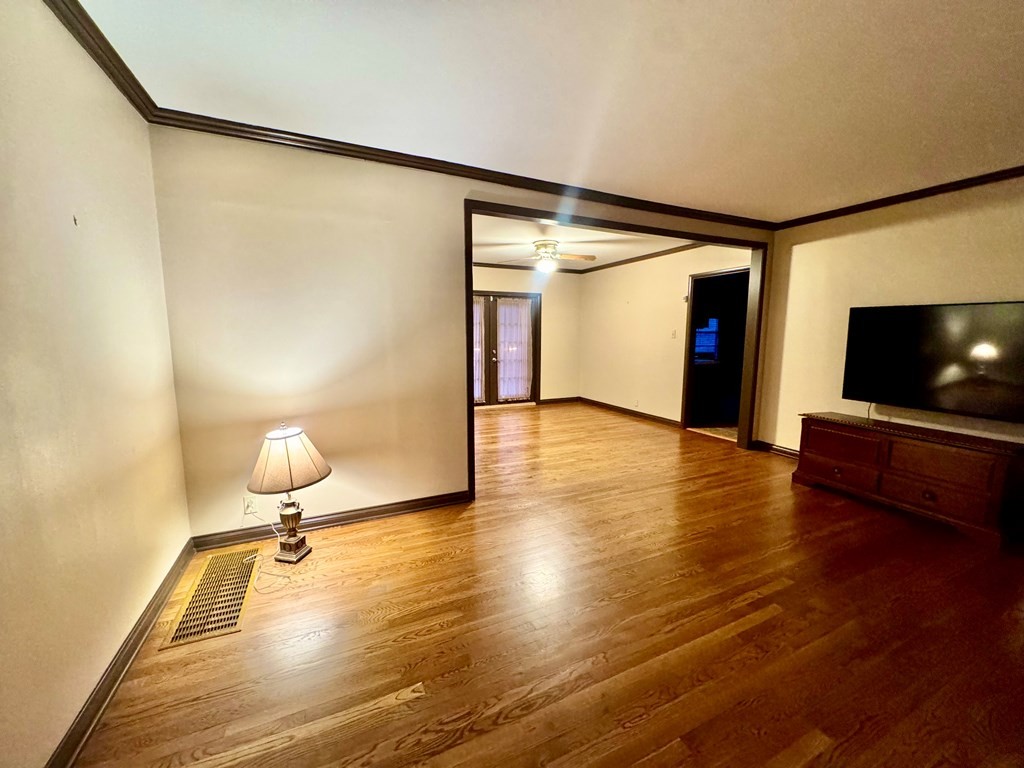 147 Berry Street Camden, TN 38320 - Photo 5 of 16 a view of a livingroom with wooden floor and a flat screen tv