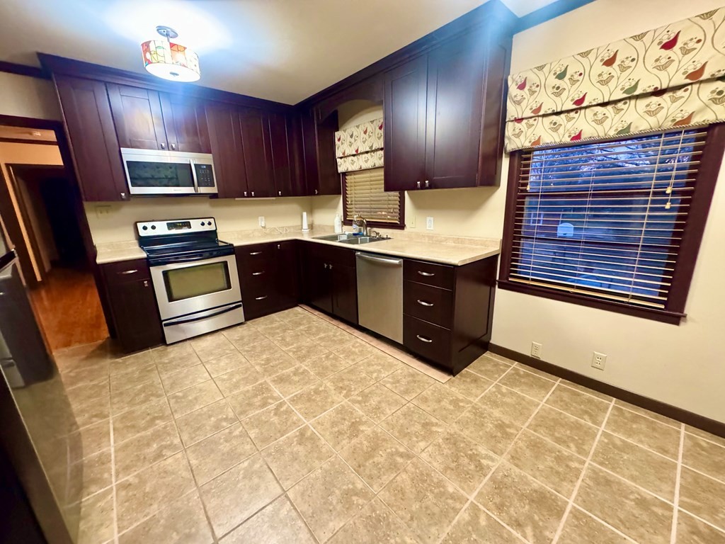 147 Berry Street Camden, TN 38320 - Photo 7 of 16 a kitchen with granite countertop a stove a sink and a microwave