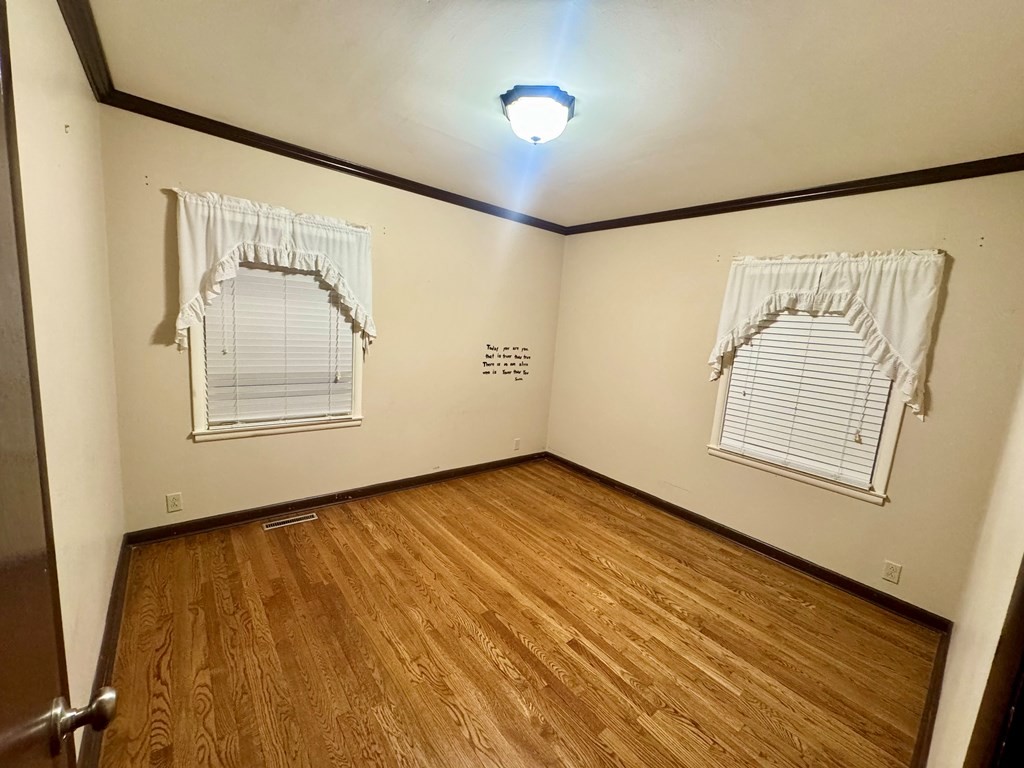 147 Berry Street Camden, TN 38320 - Photo 10 of 16 a view of an empty room with wooden floor and a window