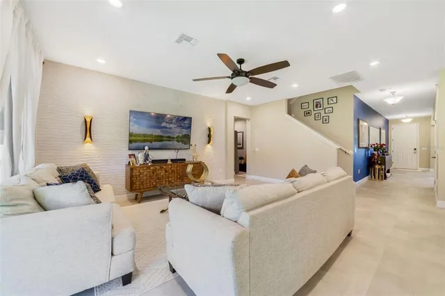 a living room with furniture and a ceiling fan