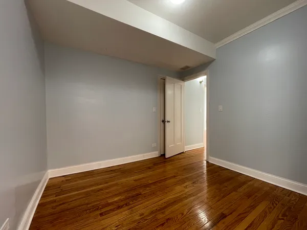a view of an empty room with wooden floor