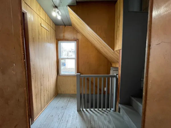 a view of a hallway with wooden floor and staircase
