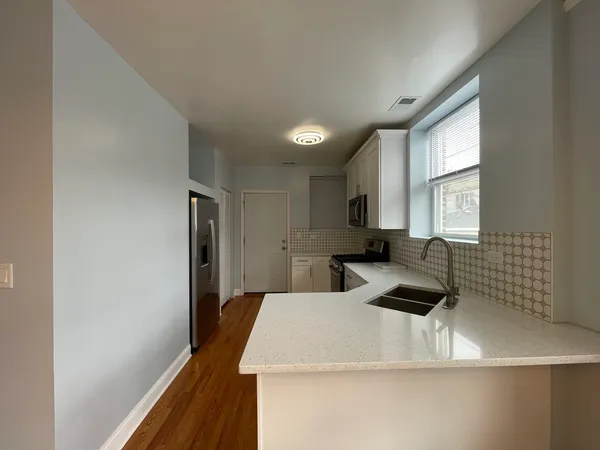 a kitchen with a refrigerator and a stove top oven