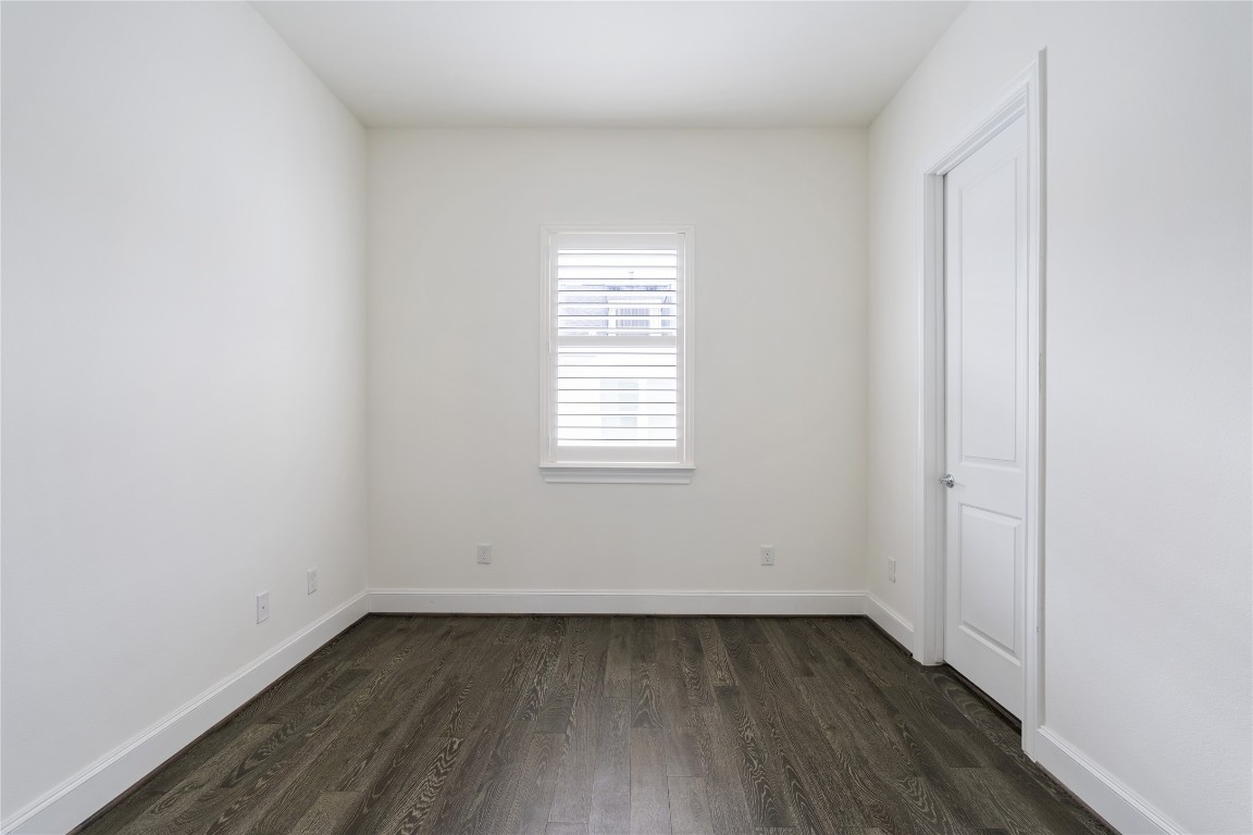 2613 Maxroy Street Houston, TX 77007 - Photo 27 of 42 The third floor bedroom is located down the hall from the primary past the utility area & features large windows & hardwood floors as well as a large closet.