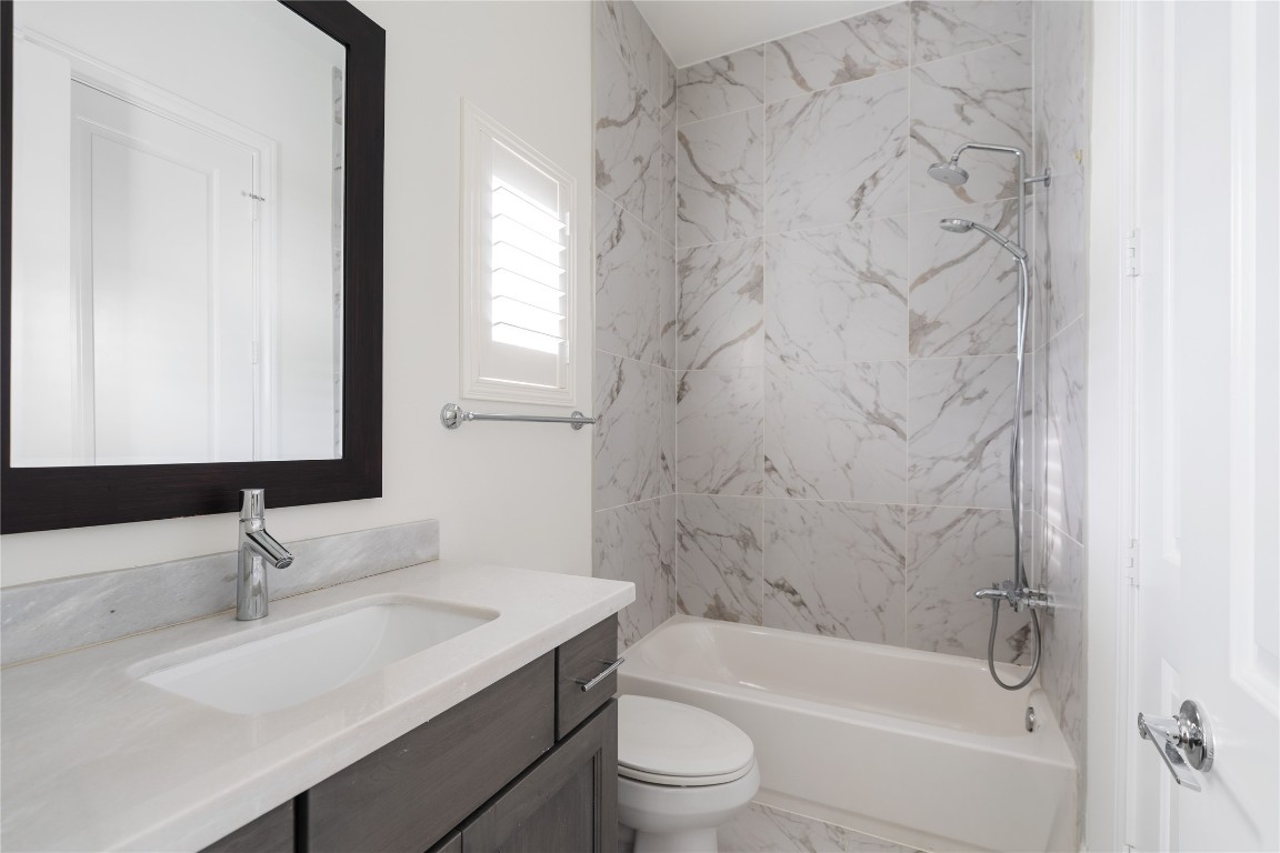 2613 Maxroy Street Houston, TX 77007 - Photo 28 of 42 The third floor bedroom's en suite bath offers a calm environment with a shower/tub combo with dual shower heads as well as a furniture-style vanity.