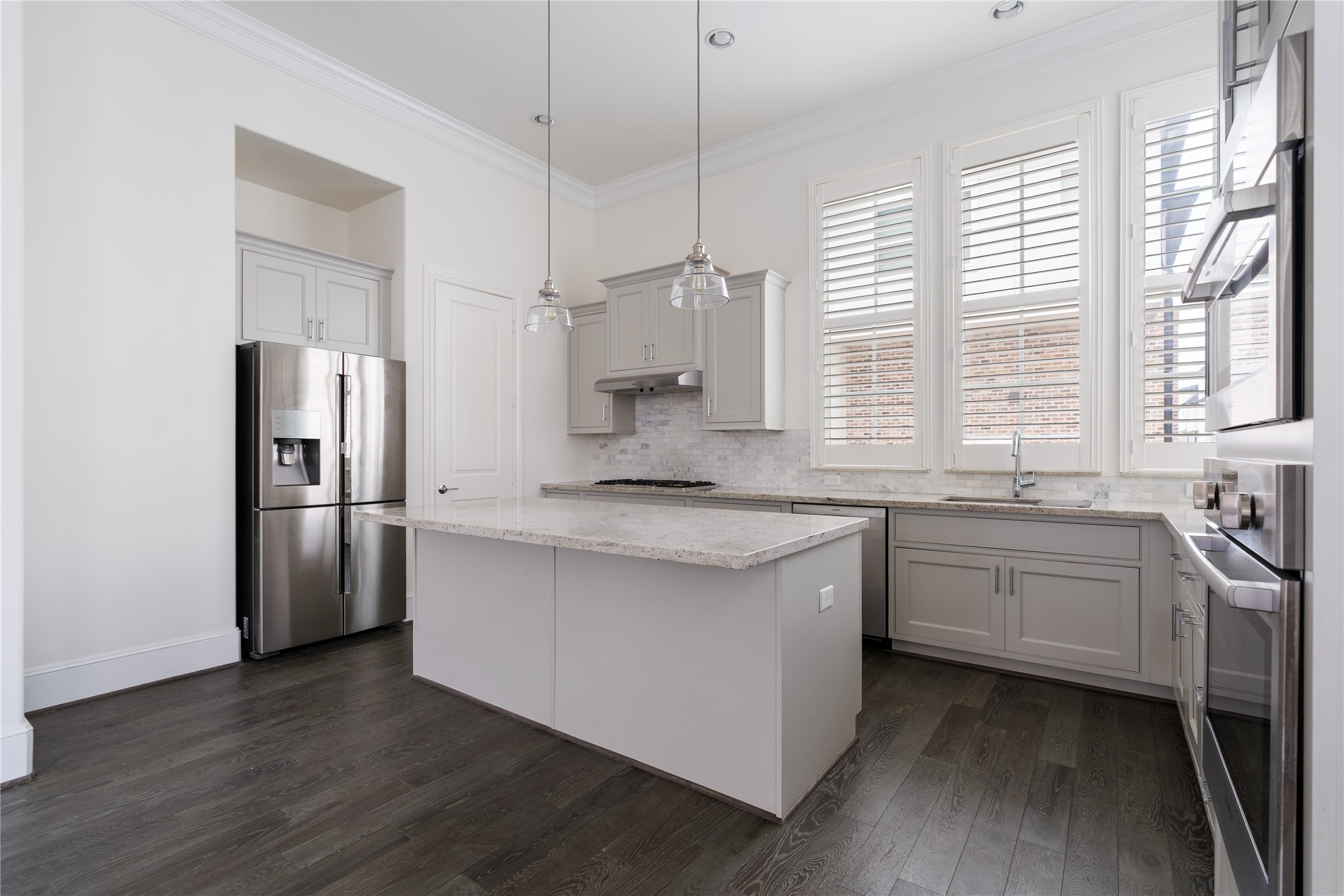 2613 Maxroy Street Houston, TX 77007 - Photo 7 of 42 Chic cabinets, soft-close doors & drawers, & stunning quartz countertops are illuminated by under-cabinet LED lighting in this large kitchen space.