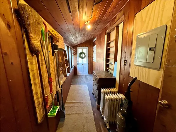 a hallway with wooden floor stairs and furniture