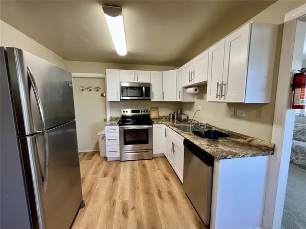 a kitchen with stainless steel appliances a refrigerator stove microwave and sink