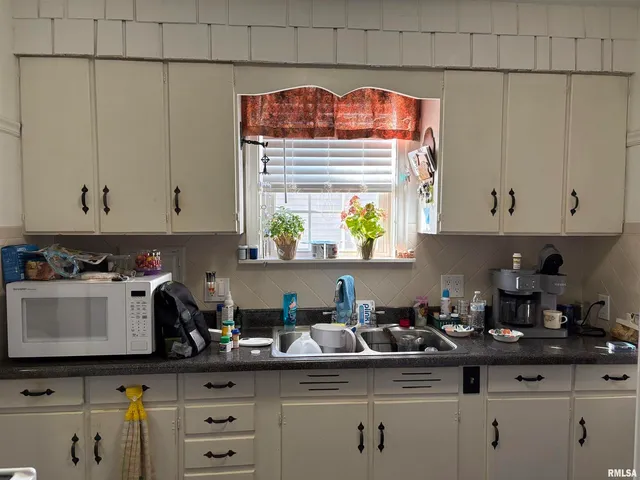 a kitchen with stainless steel appliances a white cabinets sink and a window