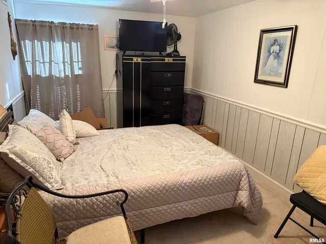 a bedroom with a bed window and a flat screen tv