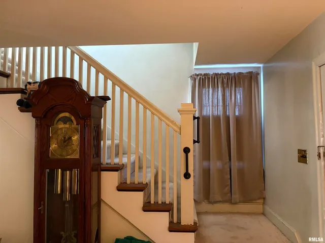 a view of staircase with railing and a window