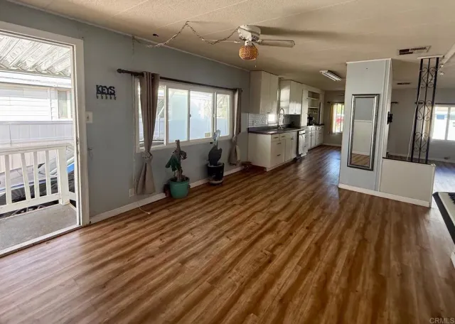 a view of a living room hardwood floor and a kitchen