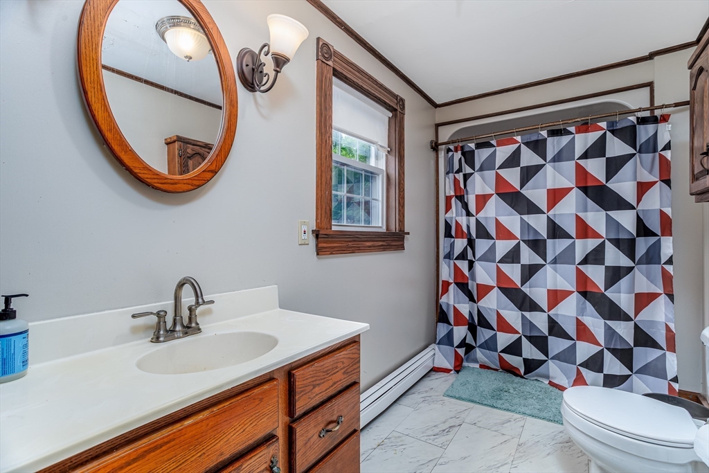 54 Charles Street Gardner, MA 01440 - Photo 18 of 40 a bathroom with a sink a mirror and a shower curtain