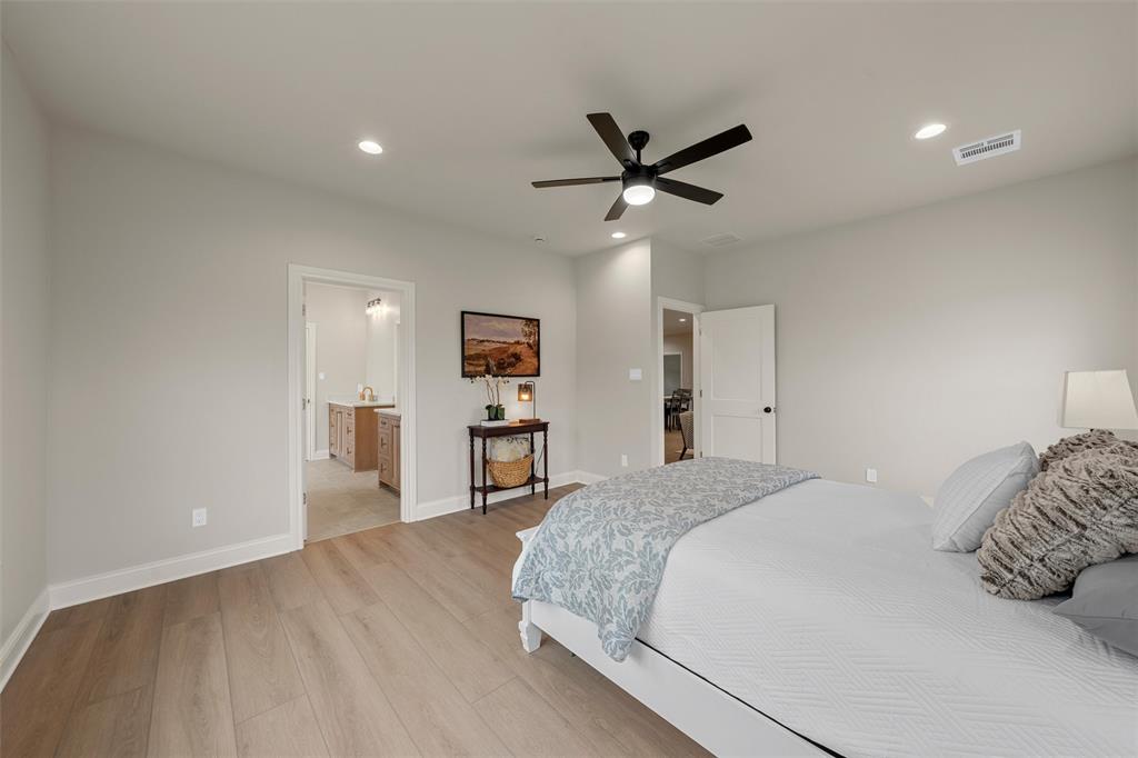 5200 Bogey Lane Waco, TX 76708 - Photo 23 of 37 a spacious bedroom with a bed and a chandelier