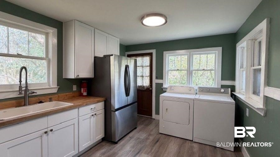 Laundry area featuring washing machine and dryer, light wood-type flooring, and plenty of natural light